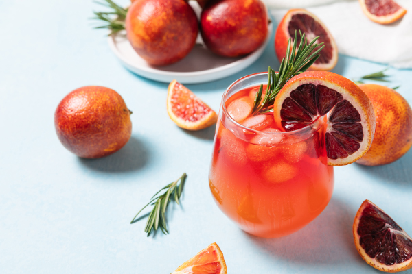 Delicious Blood Orange Cocktail on light blue background Summer